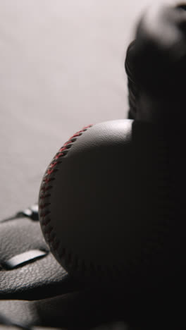 Monochromatic-Vertical-Video-Close-Up-Studio-Baseball-Still-Life-With-Bat-Ball-And-Catchers-Mitt-1